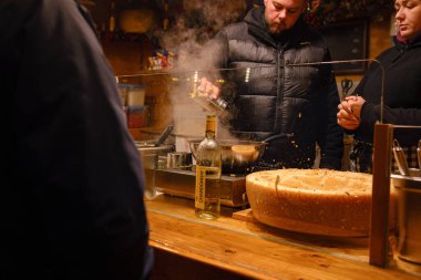 Düsselldorf, Almanya - 13 Aralık 2022: Adil Noel pazarında peynirli makarna pişirmek. Festivalde yemek hazırlığı