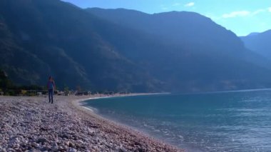 Oludeniz 'den Fethiye' ye, Lycian patikasından. Türkiye 'de seyahat. Aktif tatiller sağlıklı yaşam tarzı eko turizm. Deniz kıyısında yürüyen turist kadın.