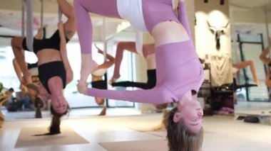 Hamakta baş aşağı asılı yoga yapan kadınlar. Hamakta meditasyon yapan genç bir kadının portresi. Formda kız fitness stüdyosunda yerçekimi yogası yapıyor.
