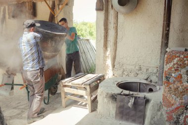 Isparta, Türkiye - 6 Haziran 2022: gül yağı damıtma çalışmalarının tüm aşamaları, Gül Yaprağı Hasadı, elle toplama. Küçük bir aile çiftliğinde parfüm endüstrisinde kullanılan güller..