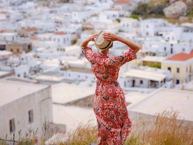 Güzel Mutlu Kadın Yunan Adaları 'nın tadını çıkarıyor. Yunanistan 'a seyahat, turizm sezonu dışında Akdeniz adaları. Deniz tatil köyü ve dağdaki eski kasaba Lindos 'un göz kamaştırıcı manzarasıyla eğleniyoruz.