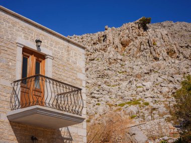 Pencereler, kapılar, Simi Adası 'ndaki eski evlerin balkonları. Yunanistan, Ege Denizi 'ndeki Rodos adalarından tatil yapıyor. Symi Körfezi 'ndeki renkli neoklasik evler. Tatil seyahat arkaplanı.