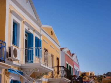 Symi Adası, Yunanistan. Yunanistan, Ege Denizi 'ndeki Rodos adalarından tatil yapıyor. Symi Körfezi 'ndeki renkli neoklasik evler. Tatil seyahat arkaplanı.