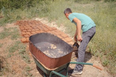Isparta, Türkiye - 6 Haziran 2022: gül yağı damıtma çalışmalarının tüm aşamaları, Gül Yaprağı Hasadı, elle toplama. Küçük bir aile çiftliğinde parfüm endüstrisinde kullanılan güller..