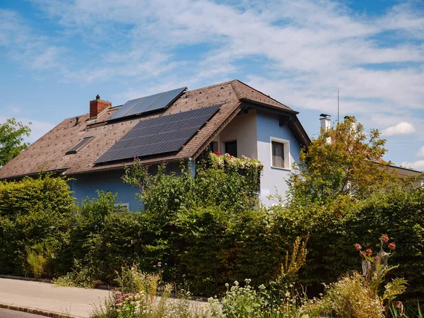 家の屋根の太陽光発電パネル 自立したエネルギーシステムを備えた現代のカントリーハウス オーストリアのウィーン郊外 クリーンで持続可能なエネルギーを活用するアイデア 電力の節約 ストックフォト