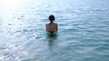 Yaz havası, Türk Rivierası 'nda deniz kenarında dinlenme. Yavaş Mo Young, siyah mayo giymiş Asyalı kadın temiz Akdeniz 'de yüzmeye gidiyor.