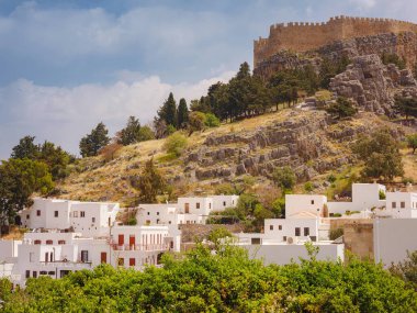 Yunanistan 'ın Lindos kenti bulutlu yaz gününde hava manzaralı, Rodos adasında beyaz evler, şehir manzaralı geleneksel Yunan mimarisi, ünlü tarihi eser ve turistik konsept