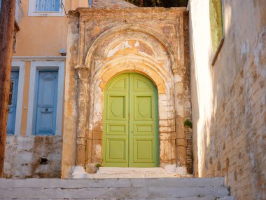 Pencereler, kapılar, Simi Adası 'ndaki eski evlerin balkonları. Yunanistan, Ege Denizi 'ndeki Rodos adalarından tatil yapıyor. Symi Körfezi 'ndeki renkli neoklasik evler. Tatil seyahat arkaplanı.