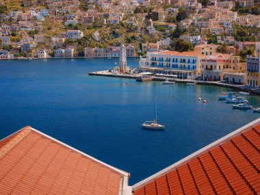 Symi Adası, Yunanistan. Yunanistan, Ege Denizi 'ndeki Rodos adalarından tatil yapıyor. Symi Körfezi 'ndeki renkli neoklasik evler. Tatil gezisi geçmişi. tepeden görünüm