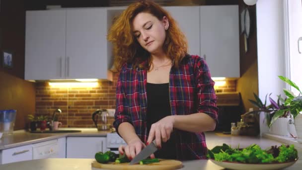 Mutfakta Genç Kızıl Saçlı Kadın Taze Salata Hazırlıyor Salatalığı Test — Stok video