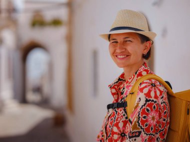 Yunan Adaları 'nda güneşli bir günün tadını çıkaran boho elbiseli güzel bir Asyalı kadın. Lindos 'a seyahat, Akdeniz adaları turizm sezonu. Yunanistan 'da tatilde olan turist kadın Lindos sokaklarında yürüyor.