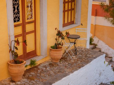 Pencereler, kapılar, Simi Adası 'ndaki eski evlerin balkonları. Yunanistan, Ege Denizi 'ndeki Rodos adalarından tatil yapıyor. Symi Körfezi 'ndeki renkli neoklasik evler. Tatil seyahat arkaplanı.