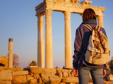 Türkiye 'nin Antalya kıyısındaki Antik Kenti' ne düşük turizm sezonunda gitmek. Genç turist Asyalı kadın Apollo tapınağının önünde poz veriyor.