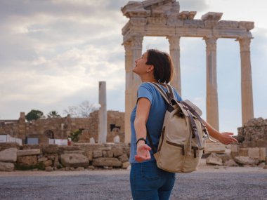 Türkiye 'nin Antalya kıyısındaki Antik Kenti' ne düşük turizm sezonunda gitmek. Genç turist Asyalı kadın Apollo tapınağının önünde poz veriyor.