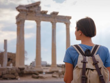 Türkiye 'nin Antalya kıyısındaki Antik Kenti' ne düşük turizm sezonunda gitmek. Genç turist Asyalı kadın Apollo tapınağının önünde poz veriyor.
