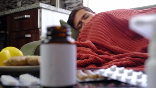 ジンジャー レモン タマネギ バックグラウンド病人のテーブル上のさまざまな薬 風邪やインフルエンザを治療するための代替療法と伝統的な丸薬 病気の男は 背景に赤い毛布に包まれました — ストック動画
