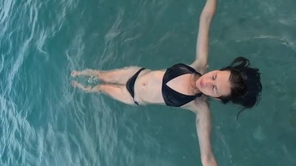 夏の気分 トルコリビエラの海によるリラクゼーション 美しい若い女性は水面に横たわり 背中に浮かんで泳いでいます — ストック動画