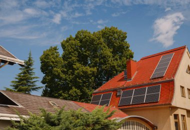 Evin çatısında güneş fotovoltaik panelleri var. Kendi kendine yeten enerji sistemine sahip modern kır evi. Viyana 'nın banliyösü, Avusturya. Temiz ve sürdürülebilir enerji kullanımı fikri, elektrikten tasarruf etmek