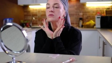 Profesyonel kozmetik ürün sonuçlarından, günlük cilt bakımından, cilt bakımından, masaj sırasında squalane veya serum kullanmaktan mutlu genç bir kadın.