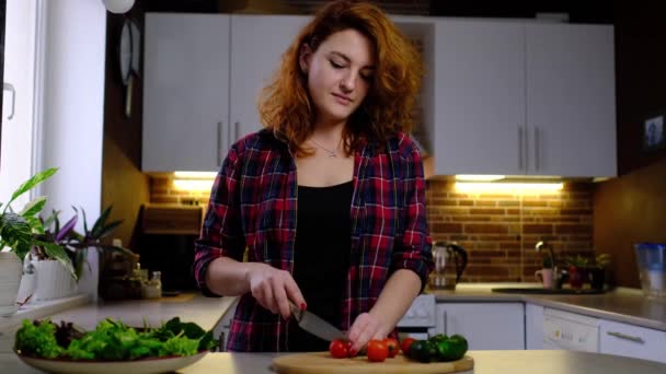 Νεαρή Κοκκινομάλλα Στην Κουζίνα Που Ετοιμάζει Φρέσκια Σαλάτα Ψιλοκομμένη Ντομάτα — Αρχείο Βίντεο