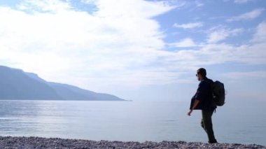 Oludeniz 'den Fethiye' ye, Lycian patikasından. Türkiye 'de seyahat. Bir adam sahil boyunca yürürken Blue Bay 'i seyretmekten zevk alır.
