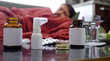 Zencefil, limon, soğan ve arka plandaki hasta adamın üzerinde farklı uyuşturucular. Alternatif ilaçlar ve soğuk algınlığı ve grip tedavisi için geleneksel haplar. Arka planda kırmızı battaniyeye sarılı hasta adam.