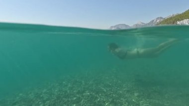 Deniz yazı manzarası. Seyahat ve tatil konsepti. Bikini giymiş kadınların tamamı, mavi denizde güneş ışınlarıyla suya dalıyor, Antalya 'da yaz tatili, Türkiye' de deniz kıyısında.