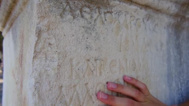 女性的手在石碑遗址上刻有碑文 是一座古老的城市 与土耳其相类似 法西里斯 Phaselis 或法西里斯 Faselis 是古希腊和古罗马的一座城市 位于古代西亚海岸 它的废墟位于Tekirova镇 — 图库视频影像