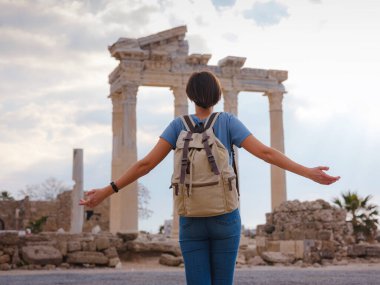 Türkiye 'nin Antalya kıyısındaki Antik Kenti' ne düşük turizm sezonunda gitmek. Genç turist Asyalı kadın Apollo tapınağının önünde poz veriyor.