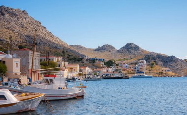 Symi ya da Simi adası limanı, klasik gemi yatları, ada tepelerindeki evler, Ege Körfezi. Yunanistan adaları Rodos adasından tatil turları düzenliyor. Symi, Yunanistan, Dodecanese.