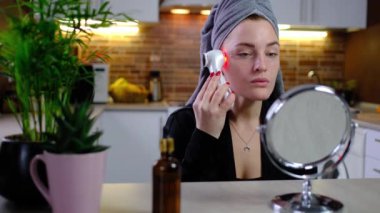 Young woman use Ultrasonic Skin Scrubber Exfoliating Wand. Skin care and age cosmetics concept. Washing and massage Face, applying spa procedures, Female facial skin care, clean the pores of dirt