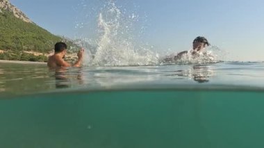 Deniz yazı manzarası. Seyahat ve tatil konsepti. Mutlu genç çift, sahilde kadın ve erkek eğleniyor. Erkek ve kadın eğleniyor. Sağlıklı aktif yaşam tarzı kavramı