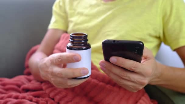 Άνθρωπος Που Χρησιμοποιεί Smartphone Μελέτες Οδηγίες Για Λήψη Χαπιών Άρρωστος — Αρχείο Βίντεο