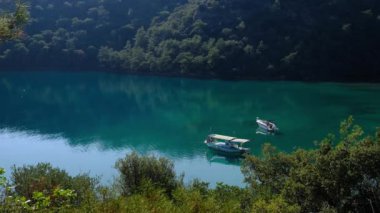 Trekking from Oludeniz to Fethiye, Lycian trail. travel in Turkey. active vacations healthy lifestyle eco tourism. two boats are parked in a beautiful bay