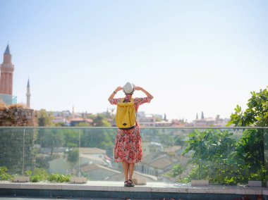 Antalya, Türkiye 'ye yaz seyahati. Kırmızı elbiseli genç Asyalı kadın eski şehir Kalechi 'de yürüyor, Panoramik Antalya Eski Kasabası, eski otoman evleri