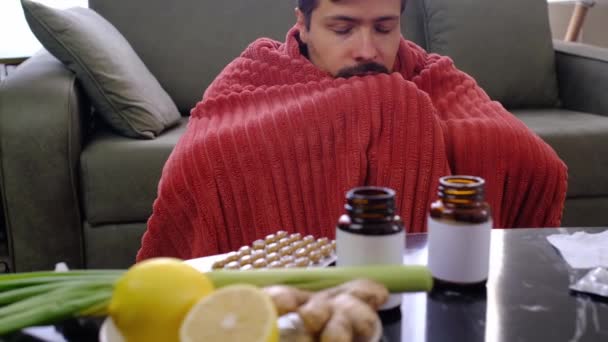 鼻抜けの若い白人男性は 自宅に座っている顔の近くに紙のナプキンを保持しています 病気の男は コビドの症状を示す悪い風邪を捕まえました またはウイルス病に苦しんでいます — ストック動画