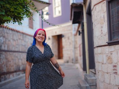 Antalya 'da yaz yürüyüşü. Renkli saçlı ve elbiseli bir kadın tarihi sokaklarını incelikle keşfediyor. Geçmiş ve şimdiki zamanı uyumlu hale getiren görsel senfoni yaratmak.