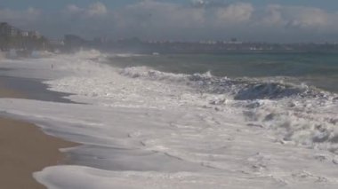 Akdeniz, Konyaalti, Antalya ve Türkiye 'de güçlü dalgalar hakim. Fırtınalı dalgalar köpüklü köpüklü deniz, mavi gökyüzü.