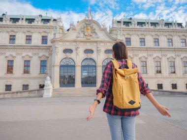 Avusturya 'da seyahat eden kadın turist, başkent Viyana' da. Avrupa 'ya yaz kadın yalnız gezisi, Barok tarzı Belvedere sarayı yakınlarında parkta yürüyen mutlu genç bir kadın..