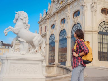 Avusturya 'da seyahat eden kadın turist, başkent Viyana' da. Avrupa 'ya yaz kadın yalnız gezisi, Barok tarzı Belvedere sarayı yakınlarında parkta yürüyen mutlu genç bir kadın..