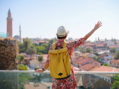 Antalya, Türkiye 'ye yaz seyahati. Kırmızı elbiseli genç Asyalı kadın eski şehir Kalechi 'de yürüyor, Panoramik Antalya Eski Kasabası, eski otoman evleri