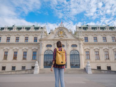 Avusturya 'da seyahat eden kadın turist, başkent Viyana' da. Avrupa 'ya yaz kadın yalnız gezisi, Barok tarzı Belvedere sarayı yakınlarında parkta yürüyen mutlu genç bir kadın..