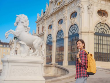 Avusturya 'da seyahat eden kadın turist, başkent Viyana' da. Avrupa 'ya yaz kadın yalnız gezisi, Barok tarzı Belvedere sarayı yakınlarında parkta yürüyen mutlu genç bir kadın..