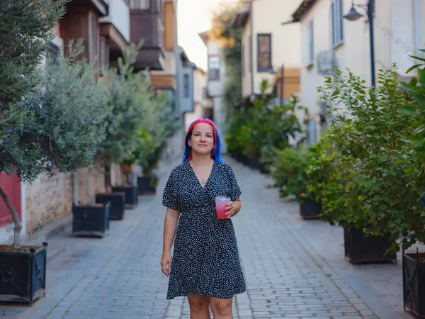 female summer old town walk in Antalya Turkey. Woman with colorful hair and dress strolls through enchanting old town of Antalya , vibrant fusion of fashion and history