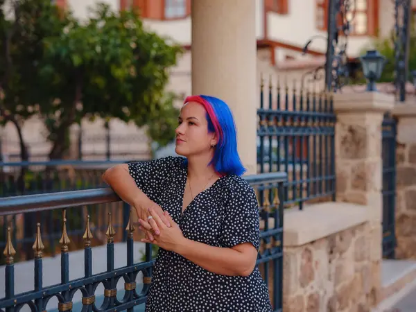 female summer old town walk in Antalya Turkey. woman with colorful hair and dress gracefully explores its historic streets. creating visual symphony that harmonizes past and present.