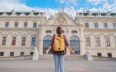 Avusturya 'da seyahat eden kadın turist, başkent Viyana' da. Avrupa 'ya yaz kadın yalnız gezisi, Barok tarzı Belvedere sarayı yakınlarında parkta yürüyen mutlu genç bir kadın..