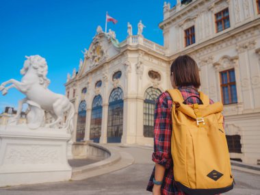 Avusturya 'da seyahat eden kadın turist, başkent Viyana' da. Avrupa 'ya yaz kadın yalnız gezisi, Barok tarzı Belvedere sarayı yakınlarında parkta yürüyen mutlu genç bir kadın..