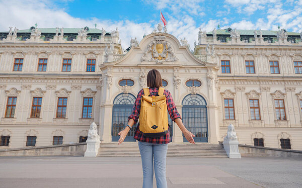 Female tourist traveling in Austria, capital city Vienna. summer female solo trip to Europe, happy young woman walking in park near Belvedere palace complex in Baroque style.