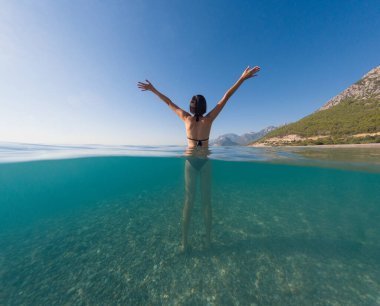 Denizde tropik tatil cennetinde bir kadın. Türk deniz kıyısında yaz tatili, Lycian Yolu 'nda plajlar, Türk Rivierası. Asyalı dişi su altı ve turkuaz okyanus çevresi.