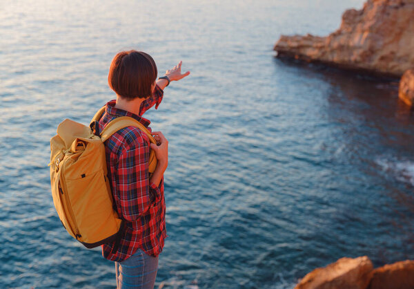 Молодая женщина, путешествующая по скалистому пляжу в Испании, Бенидорм. Наблюдая за бурным морем и заливом. Путешественник наслаждаясь свободой в спокойной природы